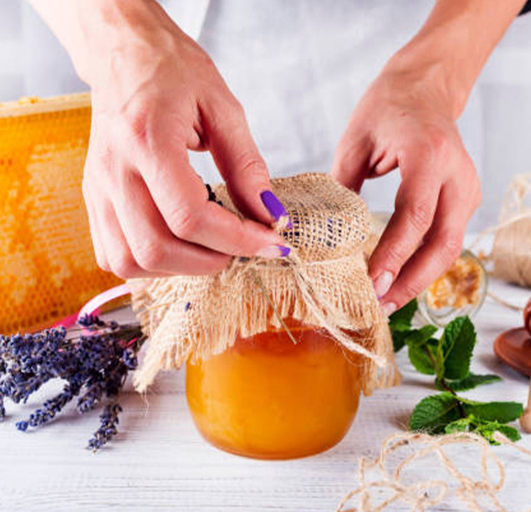 A person doing the finishing touches on a jam jar